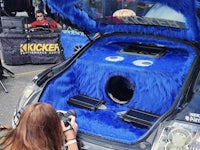 a woman takes a picture of a blue furry car